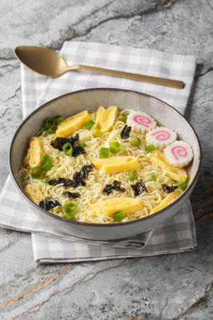 Noodle soup with nori, omelette, kamaboko and green onions closeup in the plate on the table. horizontalの写真素材