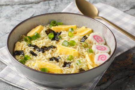 Saimin is a true Hawaiian comfort dish soft, springy noodles with nori, omelette, kamaboko and green onions closeup in the plate on the table. horizontalの写真素材