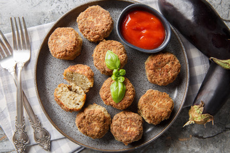 Homemade vegetarian fried eggplant balls served with tomato sauce close-up in a plate on the table. Horizontal top view from aboveの写真素材