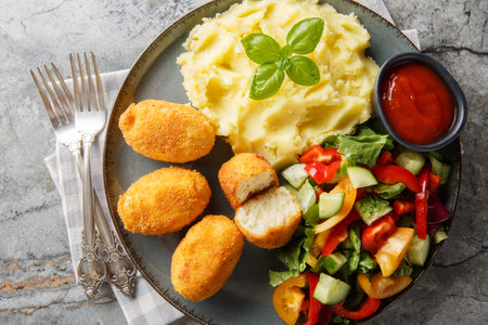 Spanish Croquettes chicken in a creamy bechamel sauce served with mashed potatoes, fresh salad and tomato sauce close-up in a plate on the table. Horizontal top view from aboveの写真素材