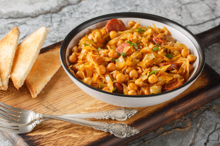Spanish Cabbage and Chickpeas known as col con garbanzos with the addition of paprika and chorizo sausages on a plate on the table. horizontalの写真素材