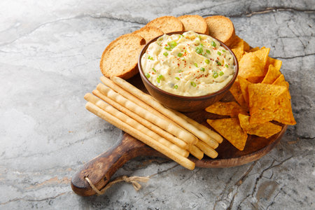 Deviled Egg Dip appetizer for a buffet or picnic with nachos, breadsticks and toast close-up on a wooden board on the table. horizontalの写真素材
