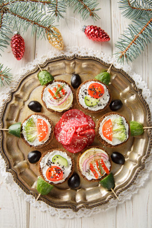 Sandwiches with cream cheese and vegetables close-up in a plate on the table. Vertical top view from aboveの写真素材