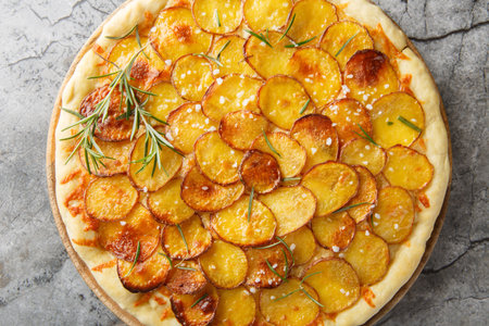 Mozzarella potato pizza and sprinkle with rosemary, salt, pepper closeup on the wooden board on the table. Horizontal top view from aboveの写真素材