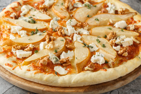 Delicious pizza with pears, gorgonzola cheese, walnuts and herbs closeup on the wooden board on the table. horizontalの写真素材