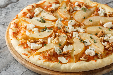 Honey pear pizza with blue cheese, nuts, mozzarella and thyme close-up on a wooden board on the table. horizontalの写真素材