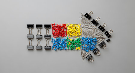 Top view of a group of colorful paperclips on grey background.の素材