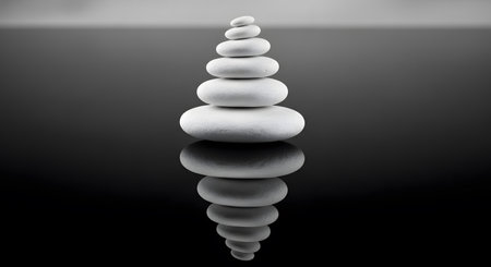 White pyramid of zen stones on a black background with reflection.の素材