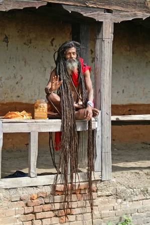 Kathmandu, Nepal - October 10, 2010: Shaiva sadhu seeking alms in front of a templeのeditorial素材
