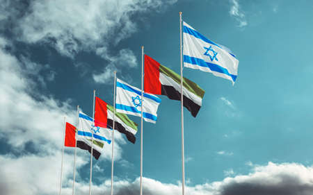 Israel and United Arab Emirates Flags low angle waving against a cloudy sky background. Israel-UAE signing historic diplomatic deal. Jerusalem and Abu Dhabi relationsの写真素材