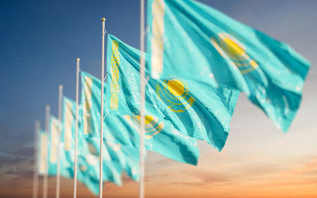 Kazakhstan national flags line-up waving in the wind at sunset sky background. Beautiful patriotic wallpaperの写真素材