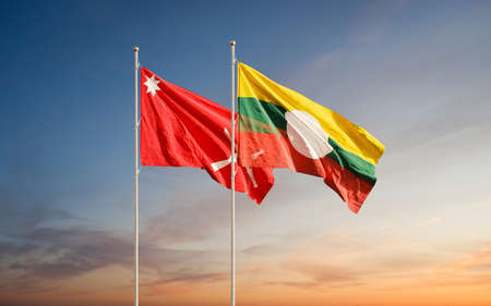 Waving flags of Shan State and Shan State Army South against sunset sky background.の写真素材