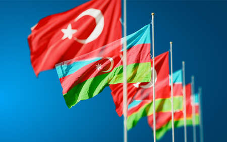 Azerbaijan and Turkey flags waving in the blue sky. Symbol of international agreement and support during Karabakh war conflict with Armenia.の写真素材