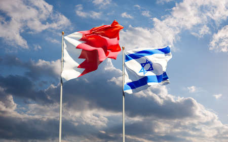 Flags of Israel and Bahrain together against the sky background. Jerusalem, Abu Dhabi and Manama signed a historic deal to normalize interstate diplomatic, economic and trade relations.の写真素材