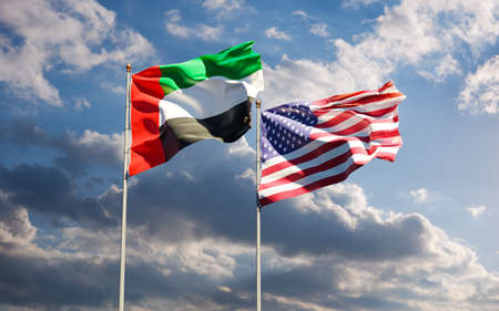 Flags of USA and UAE together against the sky background. Symbol of international relations between United States of America and United Arab Emirates.の写真素材