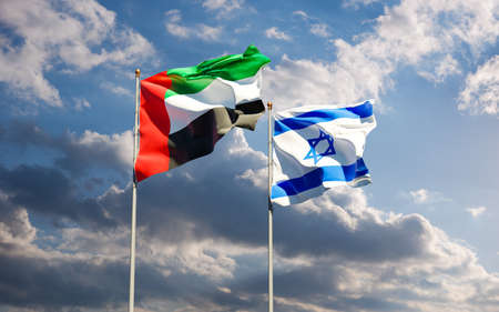 Flags of Israel and UAE together against the sky background. Jerusalem, Abu Dhabi Arab Emirates signed a historic deal to normalize interstate diplomatic, economic and trade relations.の写真素材
