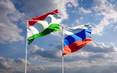 Beautiful national state flags of Tajikistan and Russia together at the sky background. 3D artwork concept.の写真素材