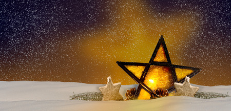Shining Christmas star at night in the snowの写真素材