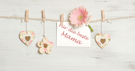 Heart, flowers and sign on clothesline on white wooden backgroundの写真素材