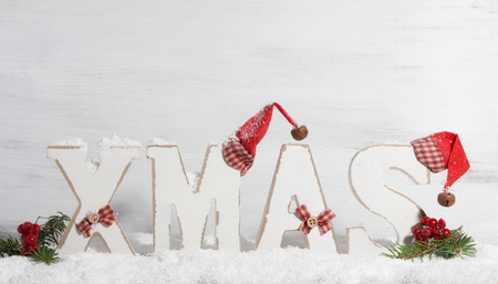Xmas, Wooden letters with Christmas hats in front of wooden backgroundの写真素材