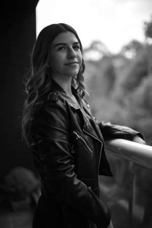 Portrait of a young woman in black and white standing, she is on her balcony. Outside your departmentの写真素材