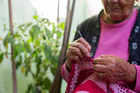Old woman knitting at home in the evening.の写真素材