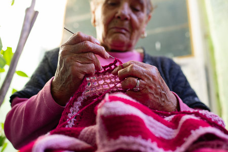 Old woman knitting at home in the evening.の写真素材
