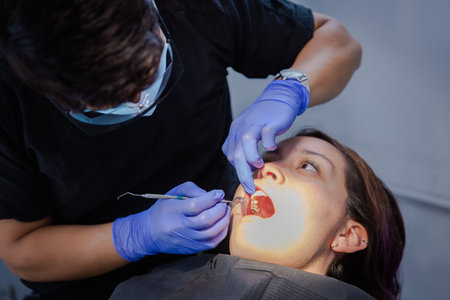Series of photos at a dentist's office. A young brunette woman sitting in a dentist's chair. A dentist giving her a lip injectionの写真素材