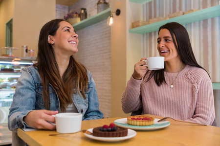 Girlfriends having breakfast sitting in a coffee shop.の写真素材