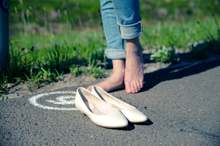 Close up of a bare feet and a pair of shoesの写真素材