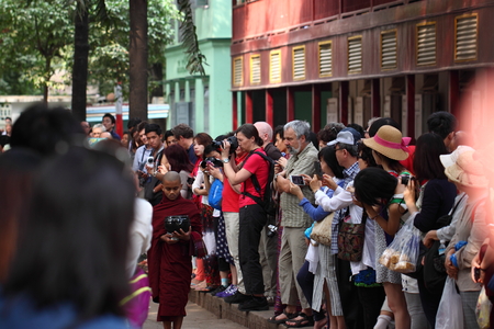 Traditional Alms giving ceremony of distributing food to buddhist monks on the streets of Mahar Gandar Yone Monastery , Myanmarのeditorial素材