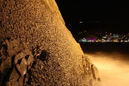 Night view of the rock sea and lights of the seaside townの写真素材