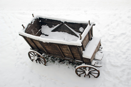 The old wooden cart in the snowの写真素材