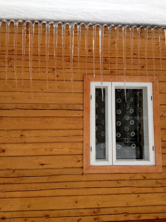 Icicles on the roof of the village houseの写真素材