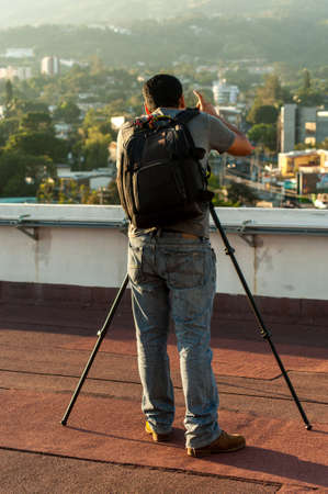 Photographer on his back on rooftopの写真素材