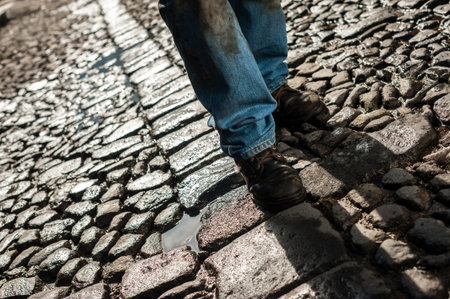 Medium shot man with dirty jeans, walking through the cobblestone streets of Antigua Guatemalaの写真素材