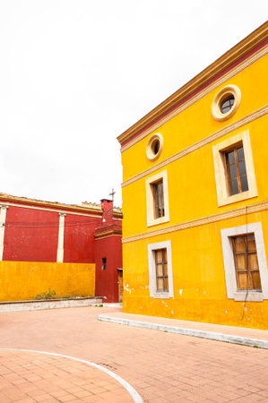 Bright yellow and red colonial facades in a street of Quetzaltenango's historic center, Guatemala. The image highlights architectural details and vibrant color contrast.の写真素材