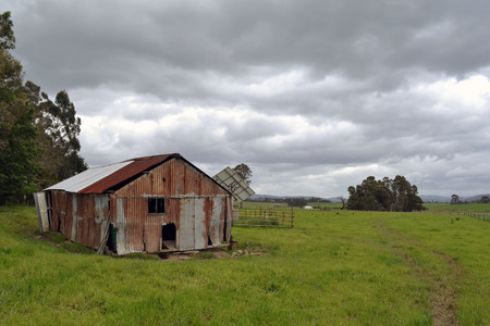 A broken house in the middle of a farmの写真素材