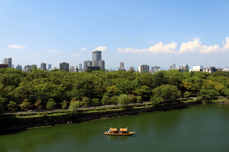 A view of a boat and the skyline of Osaka city. Pic was taken from Osaka Castle in August 2017.のeditorial素材