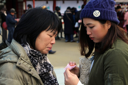 Mom & daughter checking the result of fortune-telling paper. Taken at Dazaifu Tenmangu, Fukuoka, February 2018.のeditorial素材