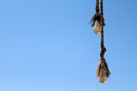 The rope and the bulb. Taken during a sunny day, with perfect blue sky, white cloud in Bali, Indonesia.の写真素材