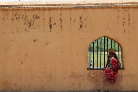 Local Indian ladies sitting on a window in Amber (Amer) Fort of Jaipur. Taken in India, August 2018のeditorial素材
