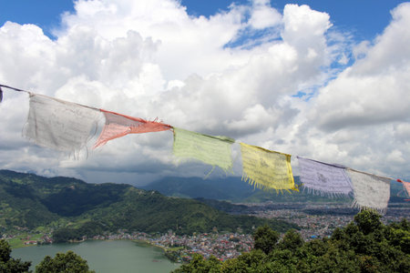 The prayer flags and Pokhara town at the World Peace Pagoda. Taken in Nepal, August 2018.のeditorial素材