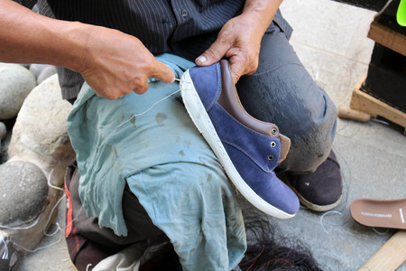 Process of manual shoe reparation, sole and welt fixing and stitching. Taken in Indonesia.の写真素材