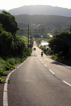 People driving motorcycle in countryside with mountains as background in Asuka. Taken in September 2019.の写真素材