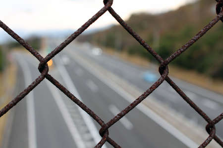 Fence overlooking blurred Japanese highway, taken in Beppu, Oita, Japan. In December 2019.の写真素材