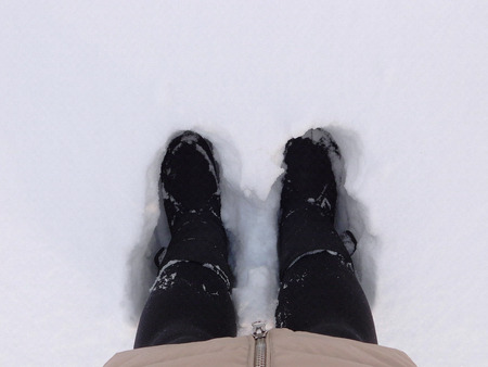 Top view of woman legs standing in a large layer of snow.の写真素材