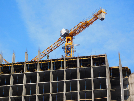 Crane and building under construction against the sky.の写真素材