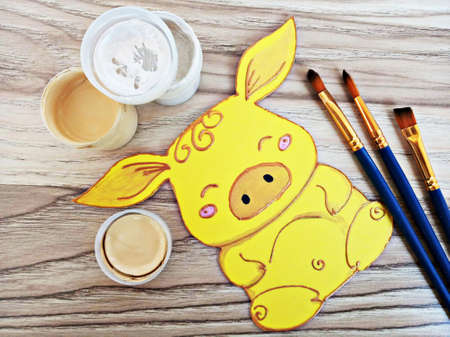 Funny paper yellow pig with paints and brushes.の写真素材