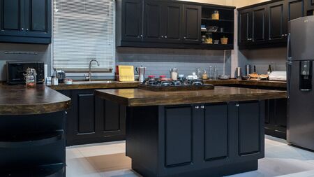 Black wood kitchen with touches of white brickの写真素材